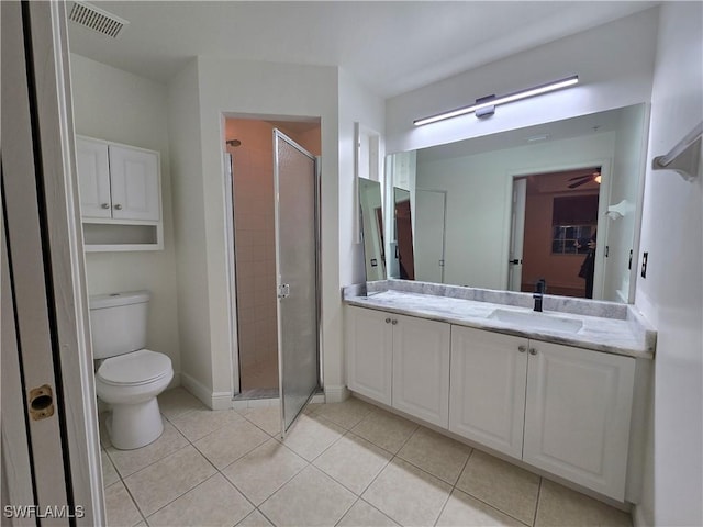 bathroom featuring a shower with door, vanity, tile patterned flooring, and toilet