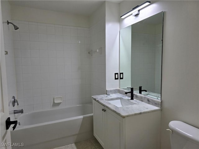 full bathroom with tiled shower / bath, vanity, tile patterned floors, and toilet