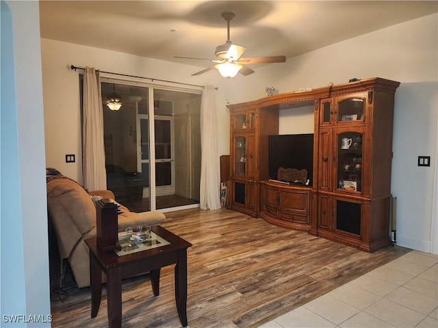 living room with ceiling fan and light hardwood / wood-style flooring