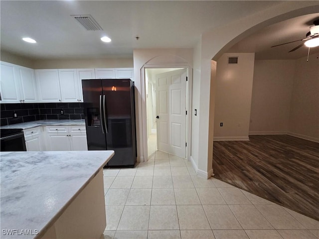 kitchen with white cabinets, backsplash, light tile patterned floors, ceiling fan, and fridge with ice dispenser