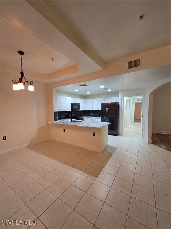 kitchen featuring light tile patterned flooring, black appliances, white cabinetry, hanging light fixtures, and kitchen peninsula