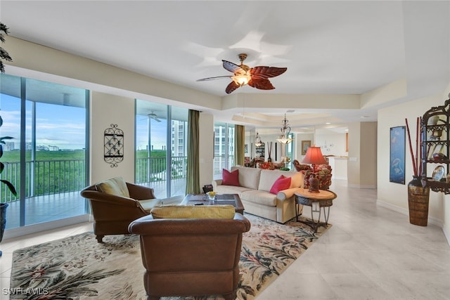 living room featuring a raised ceiling, light tile patterned flooring, and ceiling fan