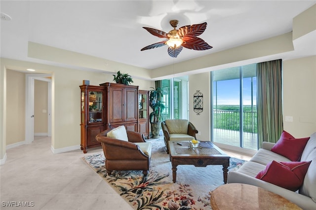 living room with ceiling fan and a tray ceiling