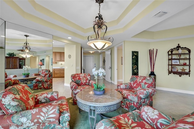 living room with light tile patterned floors and a raised ceiling