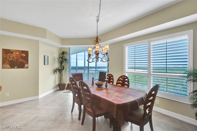 dining space with a notable chandelier and a water view