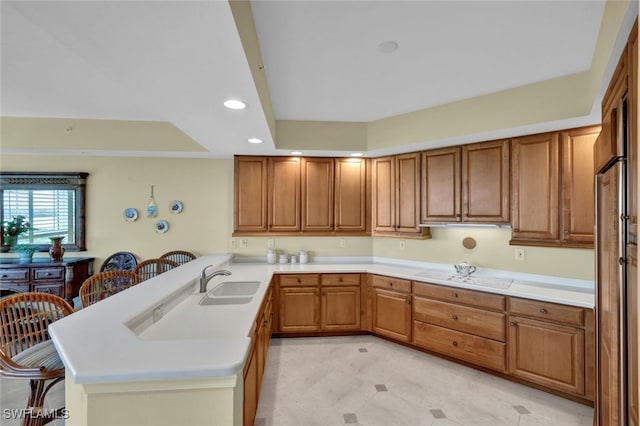 kitchen featuring sink, a breakfast bar area, and kitchen peninsula