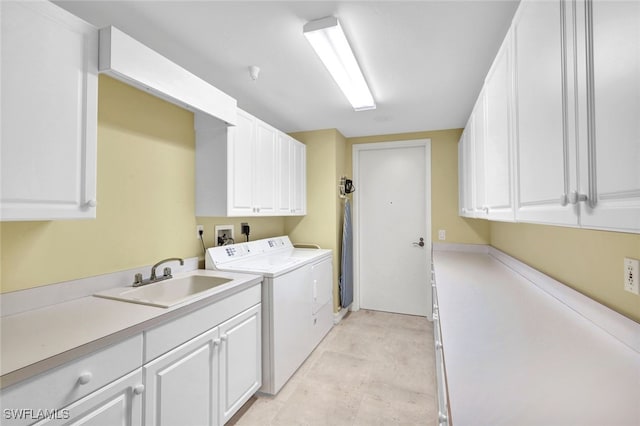 laundry room with cabinets, sink, and washing machine and dryer