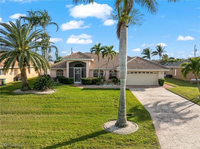 mediterranean / spanish home featuring a garage and a front lawn