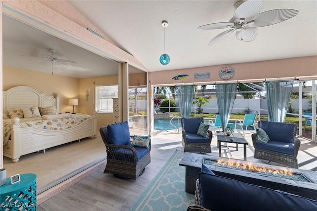 bedroom with multiple windows, access to exterior, vaulted ceiling, and hardwood / wood-style floors