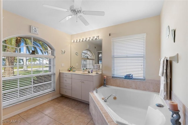 bathroom featuring vanity, tile patterned flooring, a relaxing tiled tub, and ceiling fan