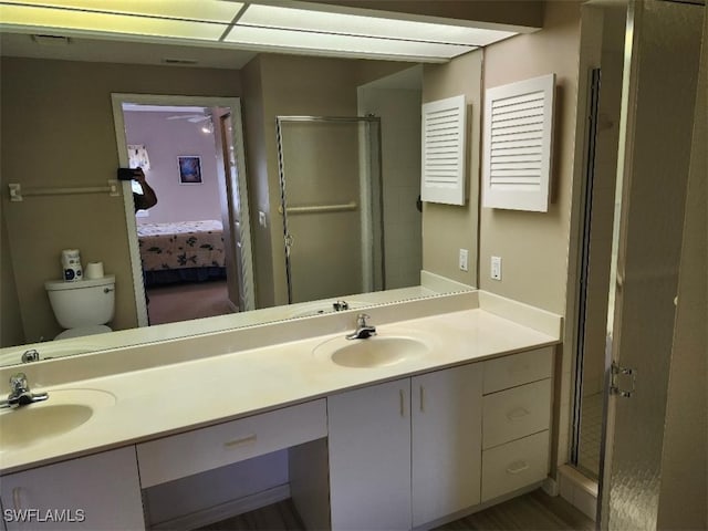 bathroom with vanity, toilet, and a shower with shower door