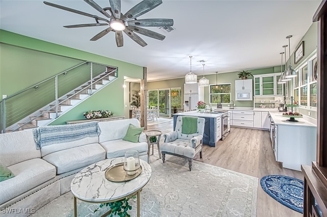 living room with ceiling fan and light hardwood / wood-style floors