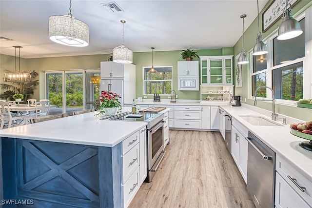 kitchen featuring sink, white cabinetry, an island with sink, pendant lighting, and stainless steel appliances