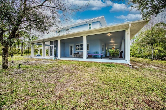 rear view of house featuring a yard and a patio