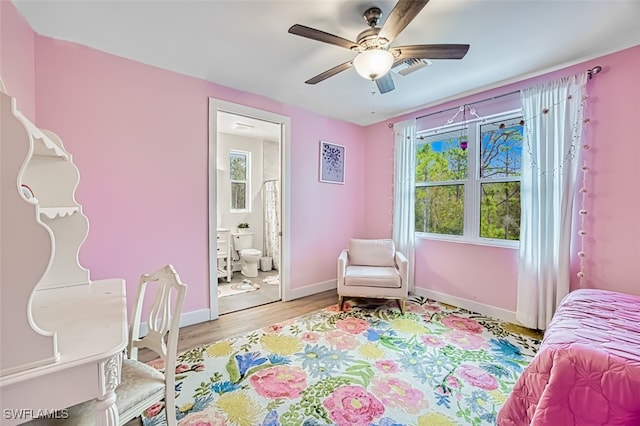 bedroom featuring ceiling fan, ensuite bathroom, and light hardwood / wood-style flooring