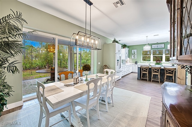 dining space featuring plenty of natural light and light hardwood / wood-style flooring