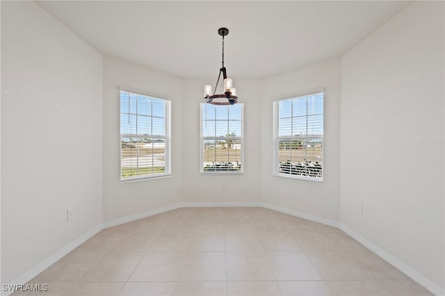 spare room with light tile patterned flooring and a chandelier