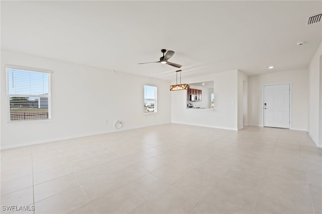 tiled spare room with ceiling fan