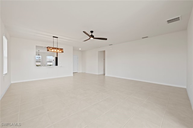 empty room with ceiling fan and light tile patterned floors