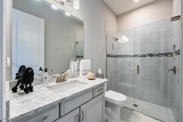 bathroom featuring vanity, an enclosed shower, and toilet