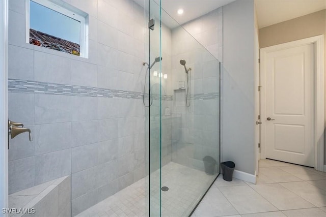 bathroom with a shower with door and tile patterned flooring