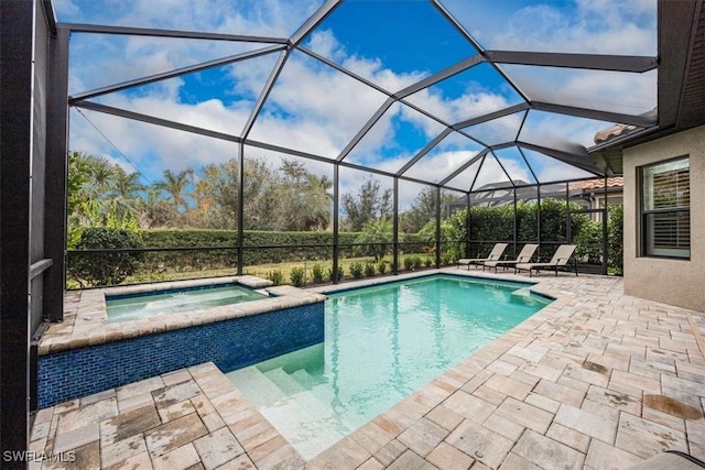 view of swimming pool featuring an in ground hot tub, a patio area, and glass enclosure