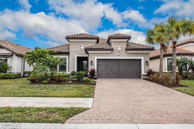 mediterranean / spanish house with a garage and a front lawn