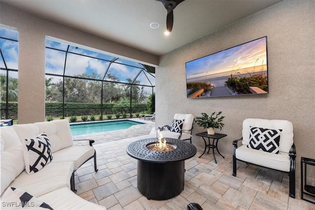 view of pool featuring a patio area, an outdoor living space with a fire pit, ceiling fan, and glass enclosure