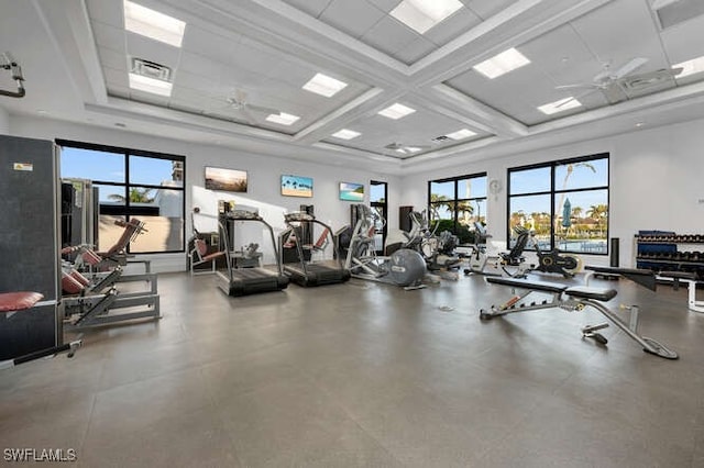 workout area with a towering ceiling, ceiling fan, visible vents, and a wealth of natural light