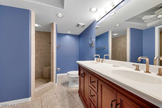 bathroom featuring toilet, walk in shower, a sink, and tile patterned floors