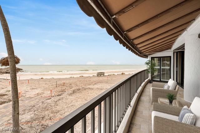 balcony featuring a water view and a view of the beach