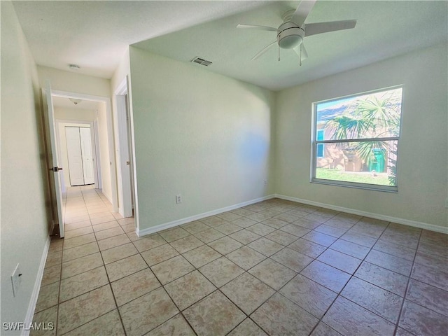 tiled empty room featuring ceiling fan