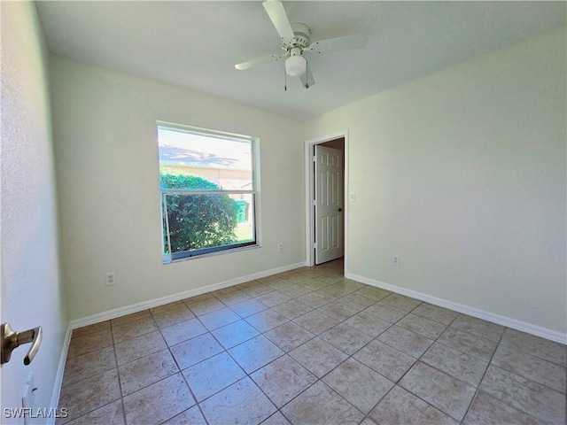 tiled spare room featuring ceiling fan