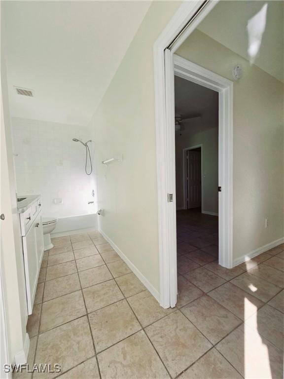 full bathroom with vanity, tiled shower / bath combo, tile patterned floors, and toilet