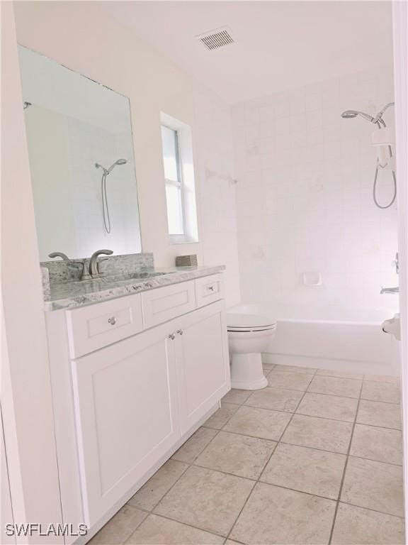 full bathroom featuring tile patterned flooring, vanity, tiled shower / bath, and toilet