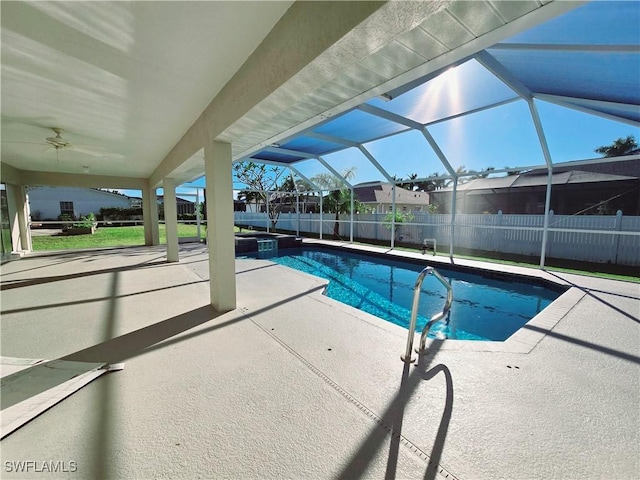 view of pool with ceiling fan, glass enclosure, and a patio area