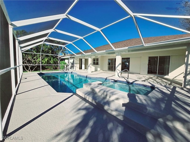 view of pool with an in ground hot tub, glass enclosure, and a patio