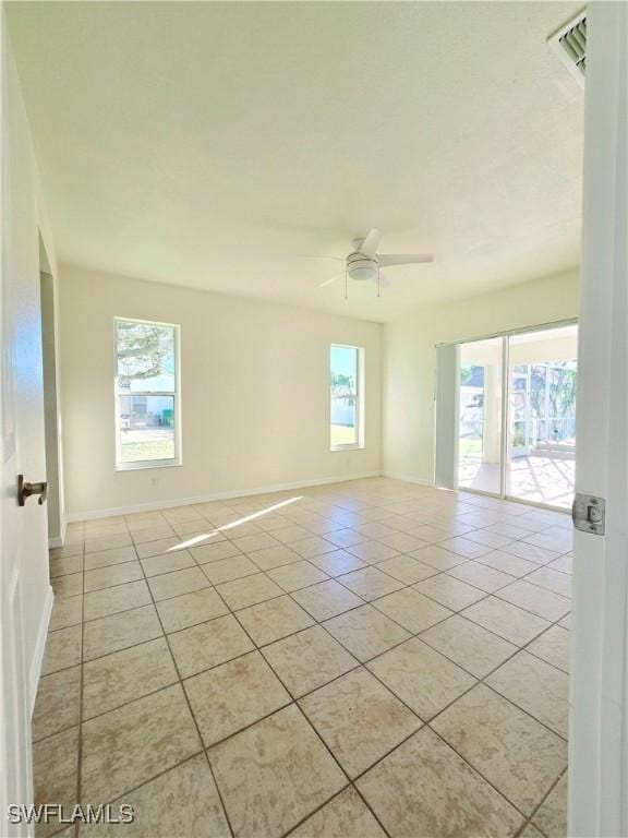 tiled spare room with ceiling fan