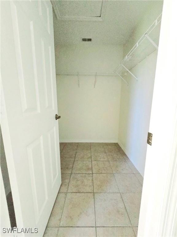 walk in closet with light tile patterned floors