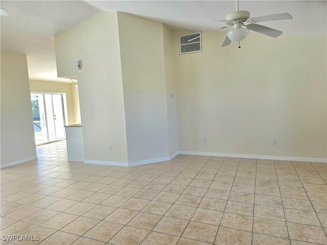 empty room featuring vaulted ceiling, light tile patterned floors, and ceiling fan