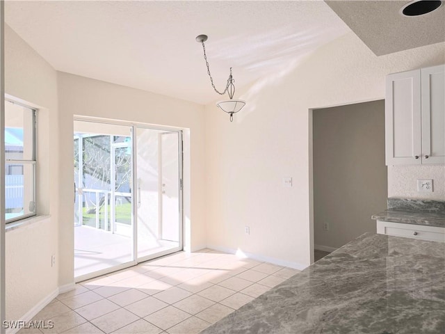 unfurnished dining area featuring light tile patterned floors