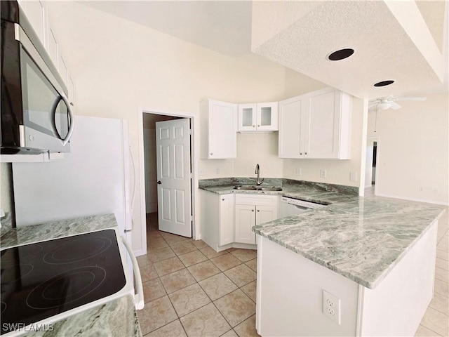 kitchen with white cabinetry, light stone counters, ceiling fan, kitchen peninsula, and white appliances