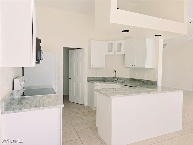 kitchen featuring sink, white cabinetry, range, light tile patterned floors, and kitchen peninsula