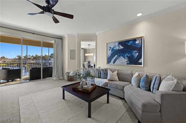 living room featuring carpet flooring, crown molding, ceiling fan, and a water view