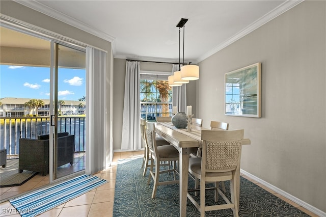 tiled dining space featuring a water view and crown molding