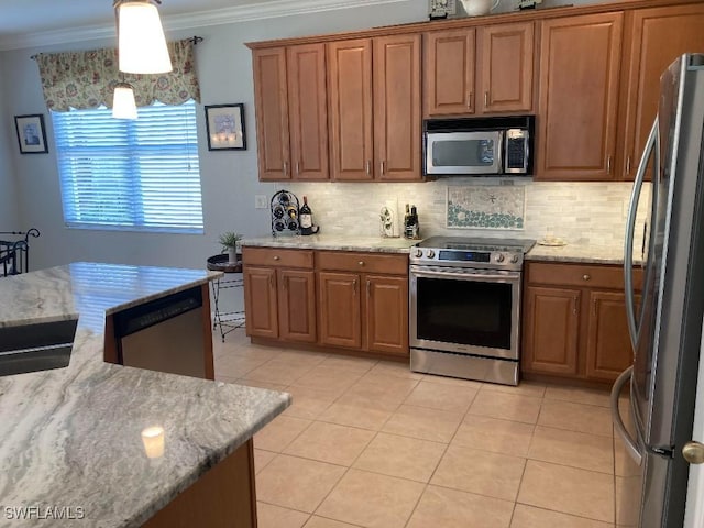 kitchen featuring light tile patterned flooring, appliances with stainless steel finishes, light stone counters, and decorative light fixtures