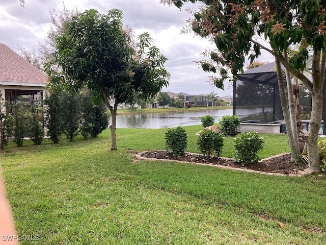 view of yard with a water view and glass enclosure