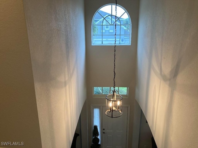 interior space featuring an inviting chandelier and a high ceiling