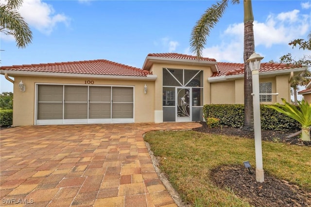 mediterranean / spanish house with a garage and a front yard