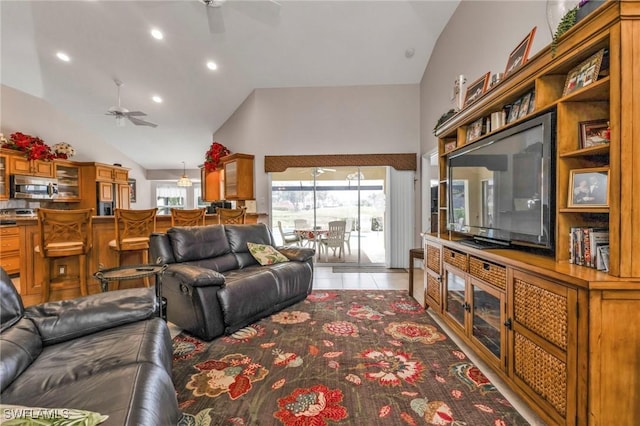 tiled living room featuring ceiling fan and high vaulted ceiling